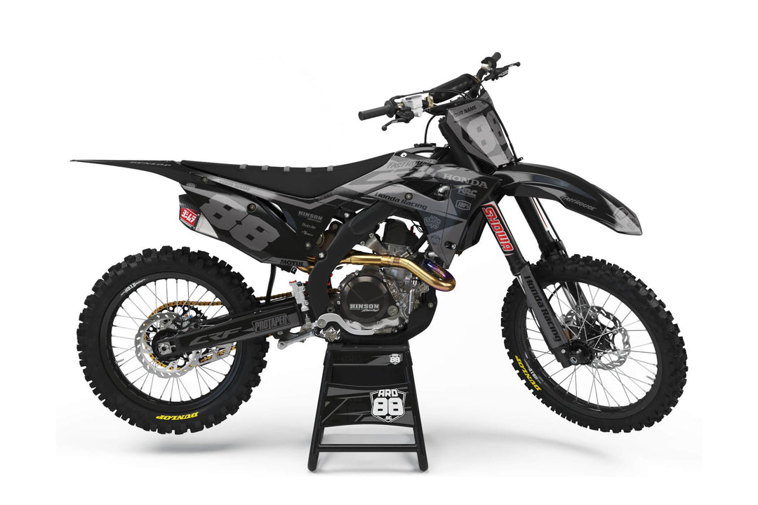 Honda crosshoj med dekalkit Gray on Black – kantigt grått mönster mot svart botten och vita siffror.