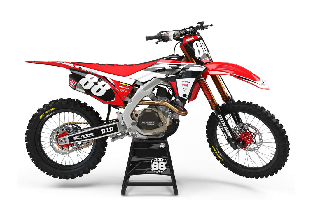 Röd Honda-crosshoj med dekalkit Race Replica – rött, vitt och svart i vinklade fält med vita siffror mot svart.