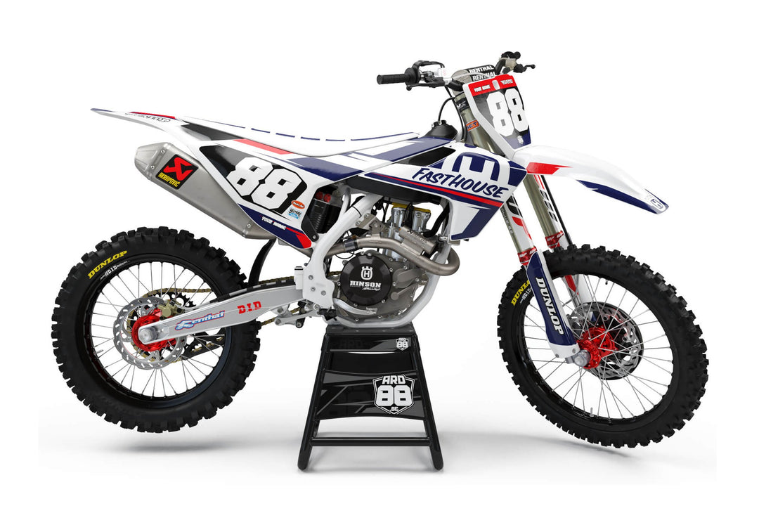 Vit Husqvarna-crosshoj med dekalkit Fasthouse II – vit botten med marinblå och röda block och vita siffror mot svart.
