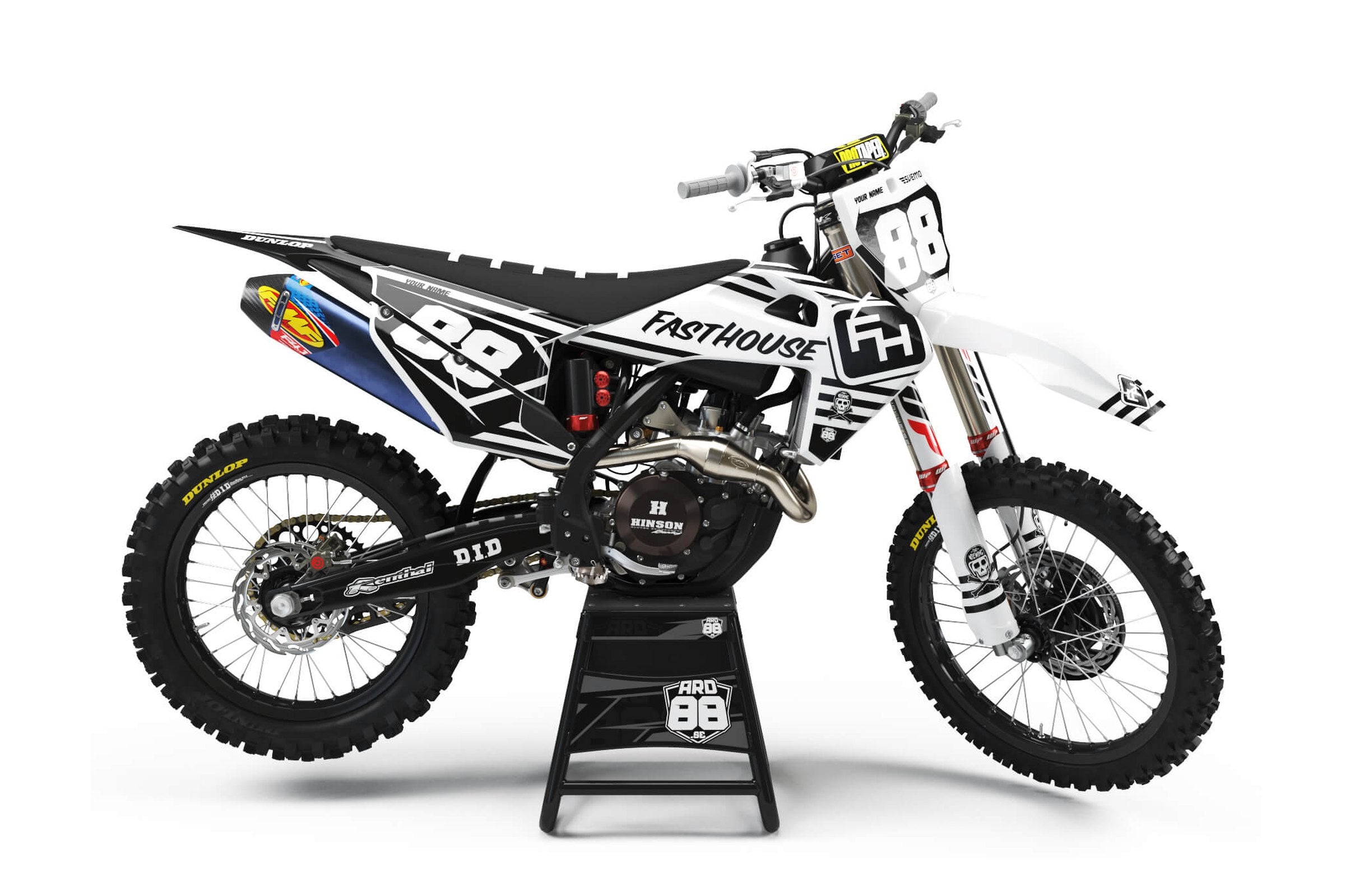Husqvarna-crosshoj med dekalkitet Fasthouse i svart och vitt, med diagonala streckfält och vita startnummer mot svart.