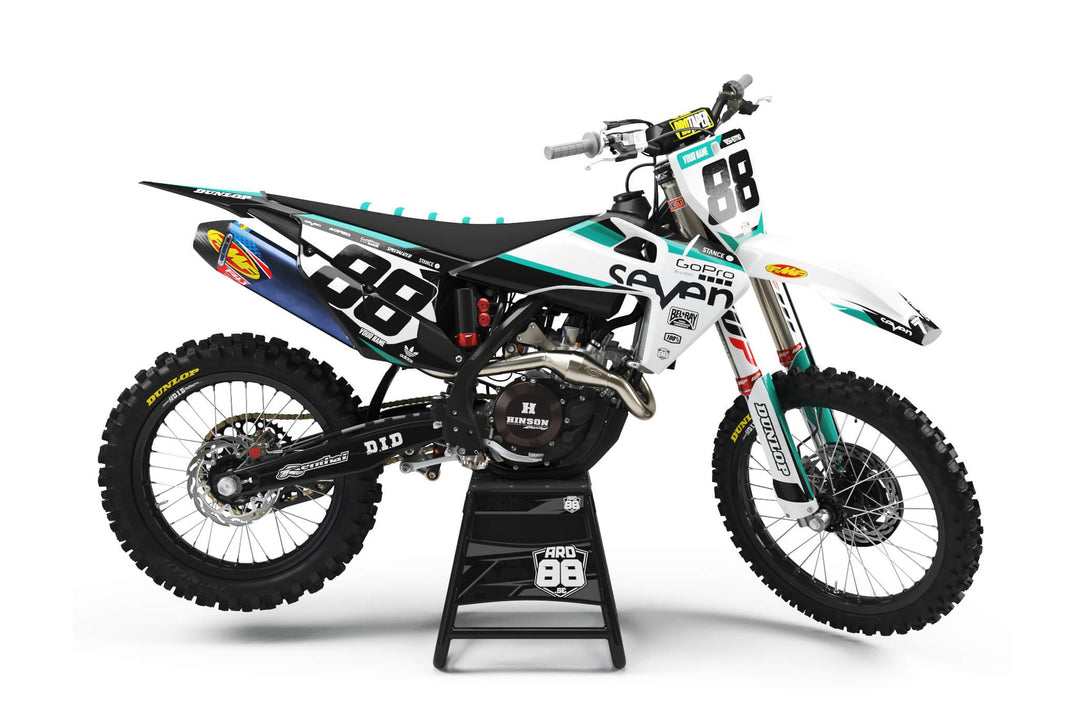 Husqvarna-crosshoj med dekalkitet Seven Teal: vit botten, turkosa linjer och vita startnummer mot svart.