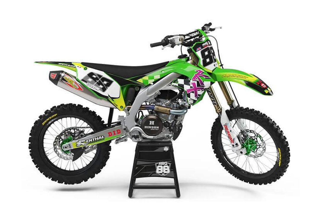 Kawasaki-crosshoj med dekalkitet Retro KX – grön och vit grafik med gula inslag, svartvitt rutmönster och mörka siffror mot vit botten