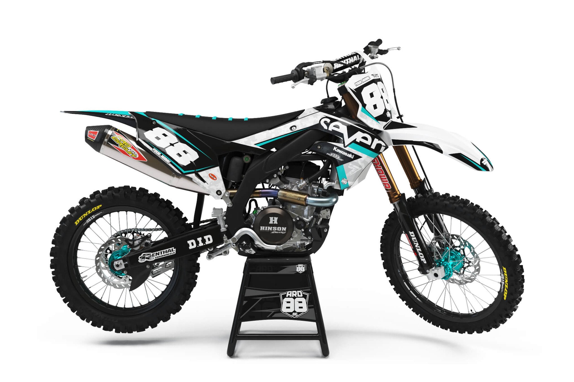 Kawasaki crosshoj med dekalkit Seven T – svart och vitt med turkosa detaljer och vita siffror.