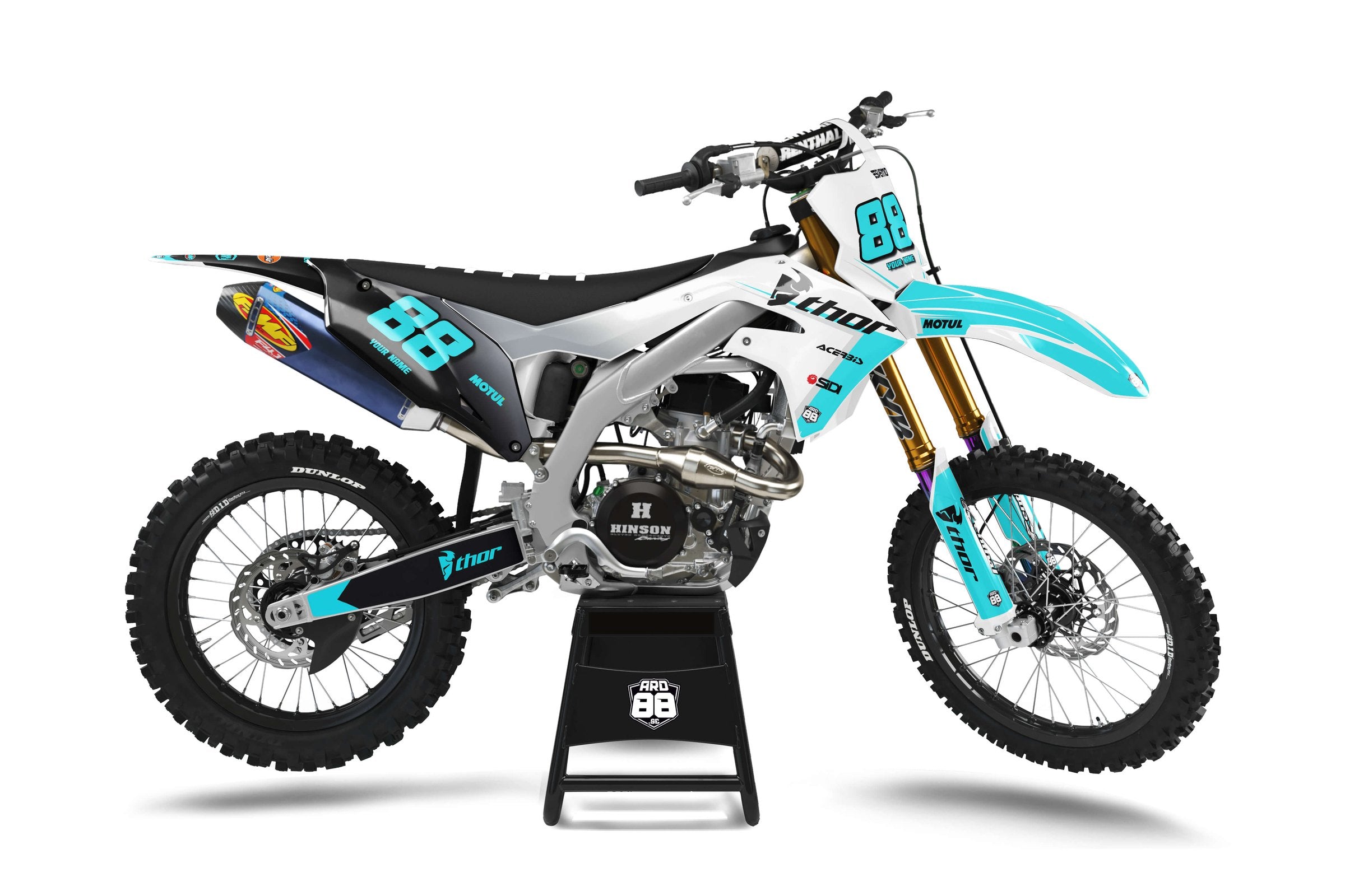 Kawasaki-crosshoj med dekalkitet Transformation Teal: svart bakparti som går över i vitt och silvergrått fram, turkosa detaljer och turkosa siffror 88