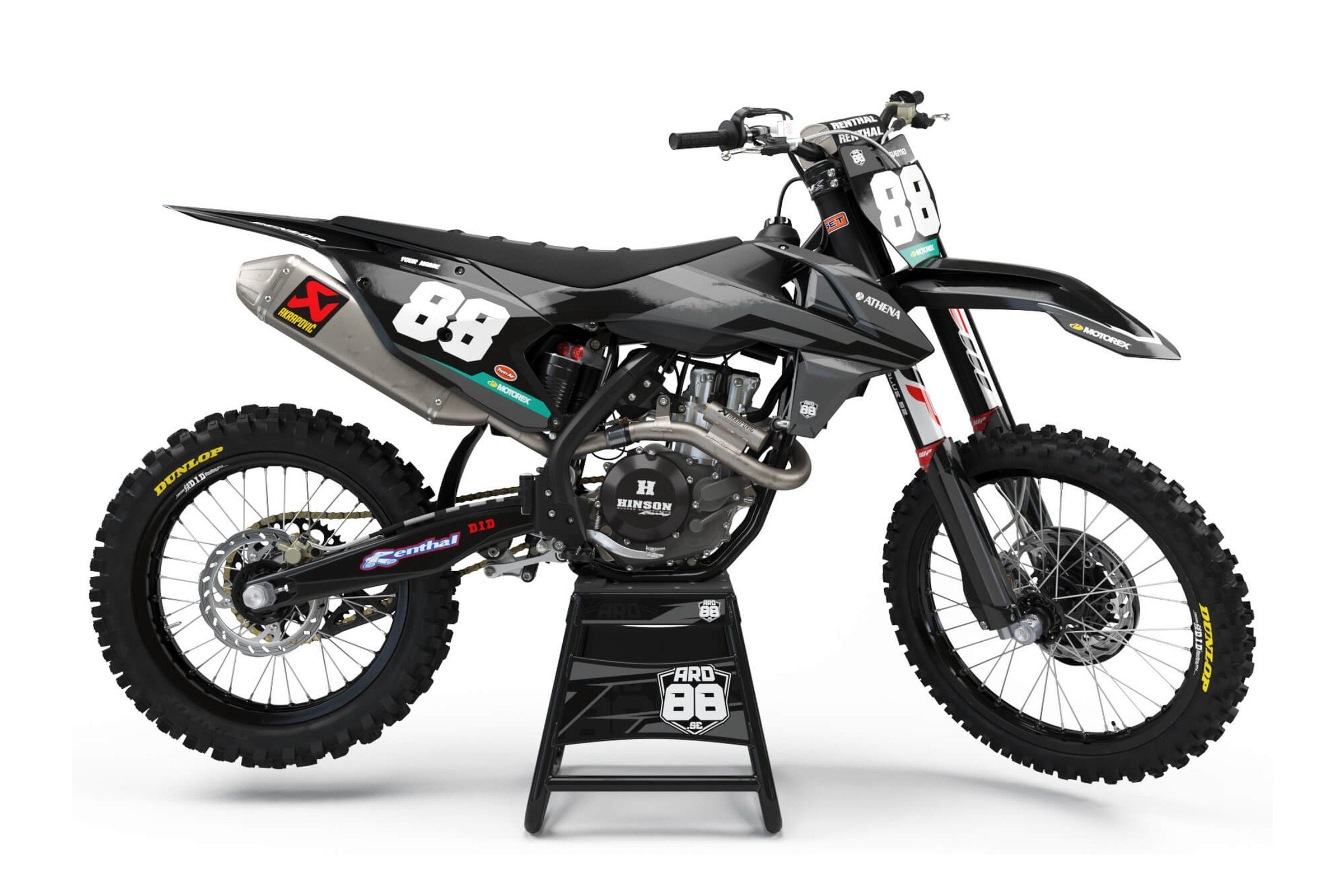 KTM-crosshoj med dekalkitet Black on Grey – svart och grå grafik med breda penseldrag, stora vita siffror och ett turkost band längst ner
