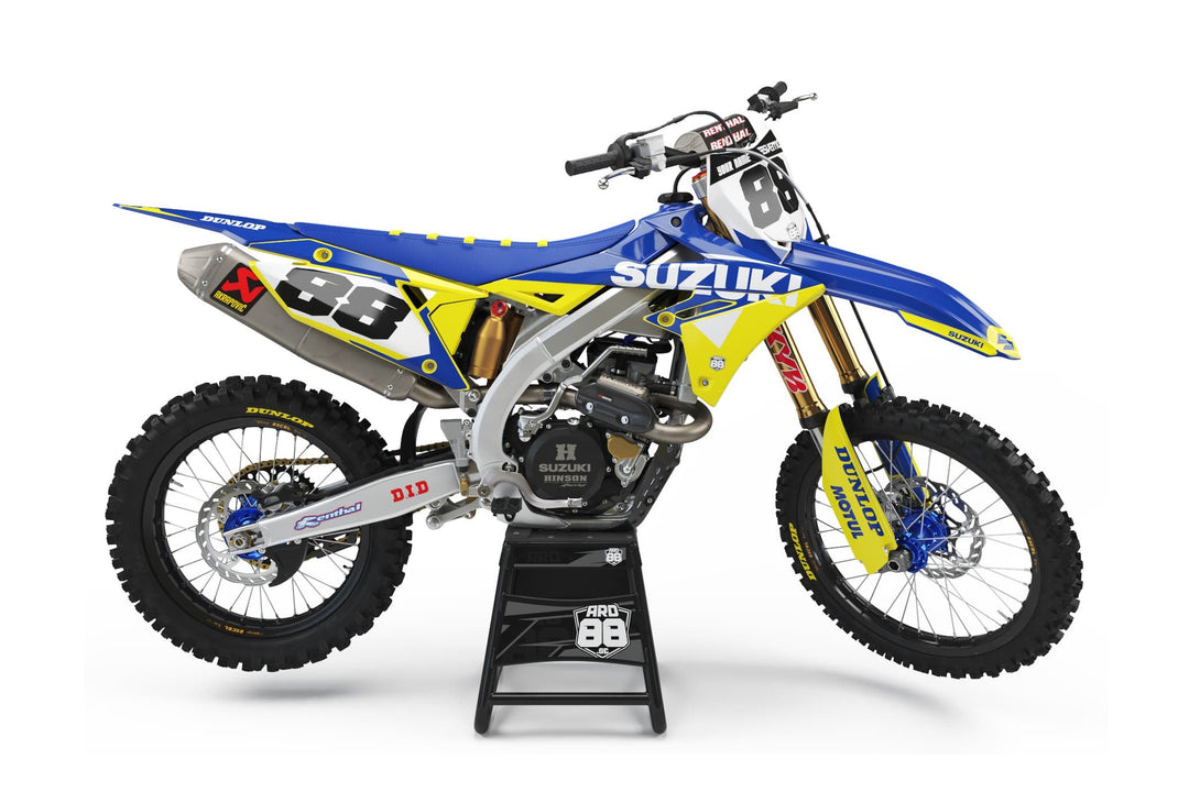 Suzuki-crosshoj med dekalkit Super Swede – blått med gula fält, vit nummerplåt och svarta siffror.
