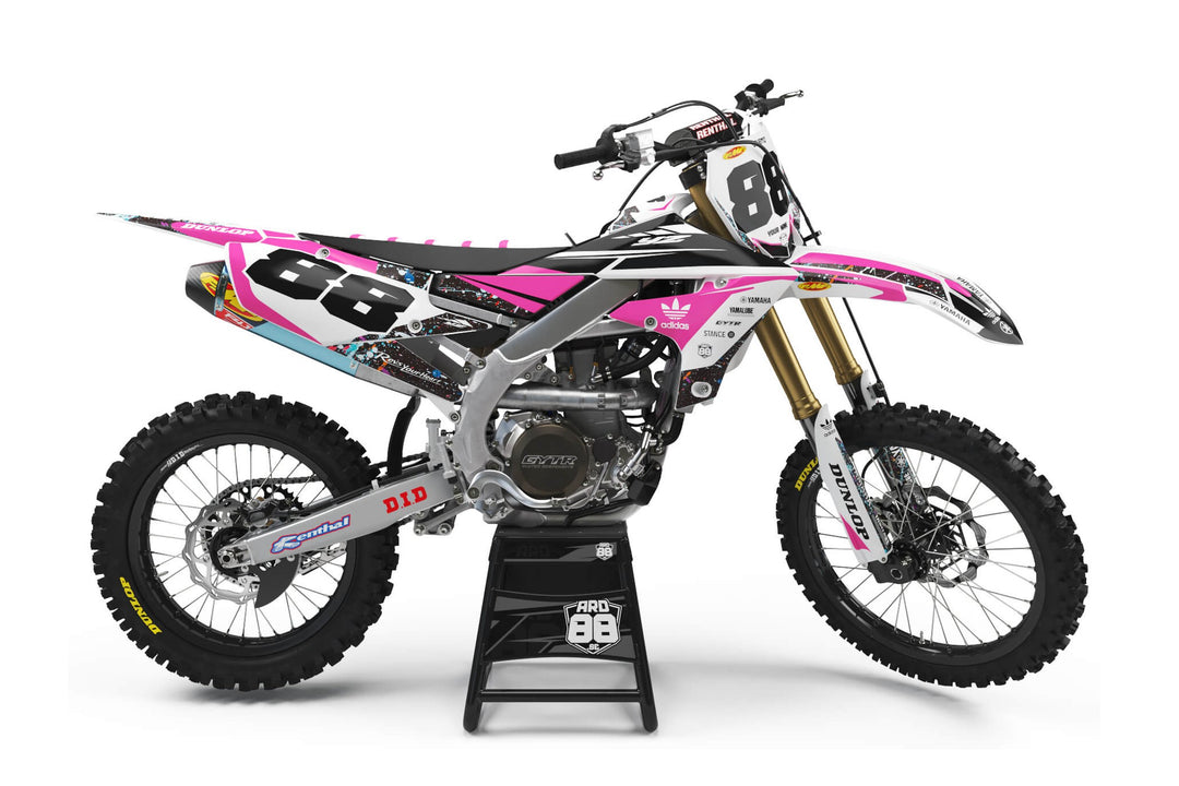 Yamaha crossmaskin med dekalkitet Spaced Out i vitt och rosa med flerfärgat stänkmönster och siffran 88