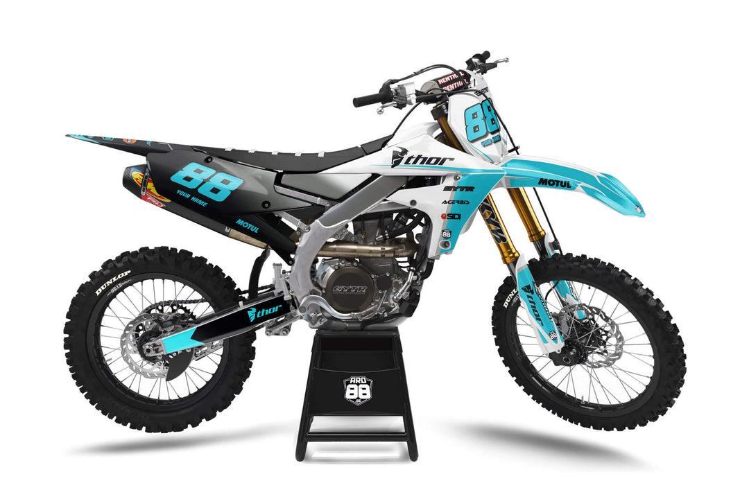 Yamaha-crosshoj med dekalkitet Tranformation Teal: svart bakparti som går över i vitt fram, turkosa detaljer och turkosa siffror 88
